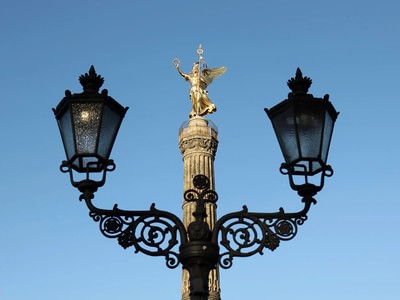 Top of the victory tower framed by a decorative streetlight tohp0eyt